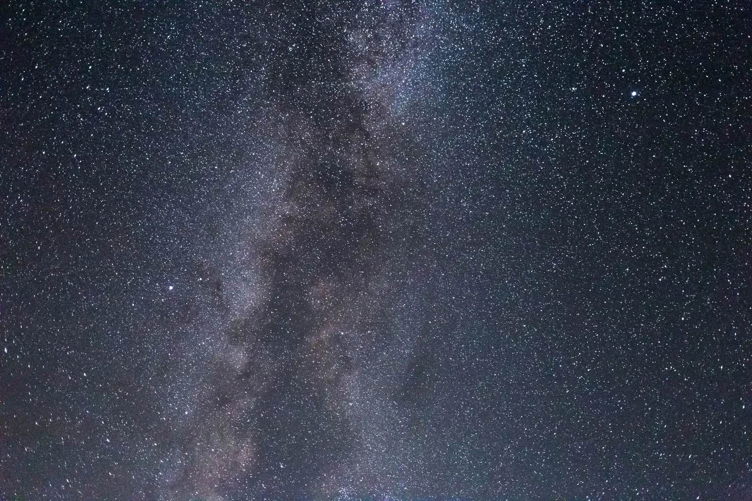 La Voie lactée dans un ciel étoilé très sombre.