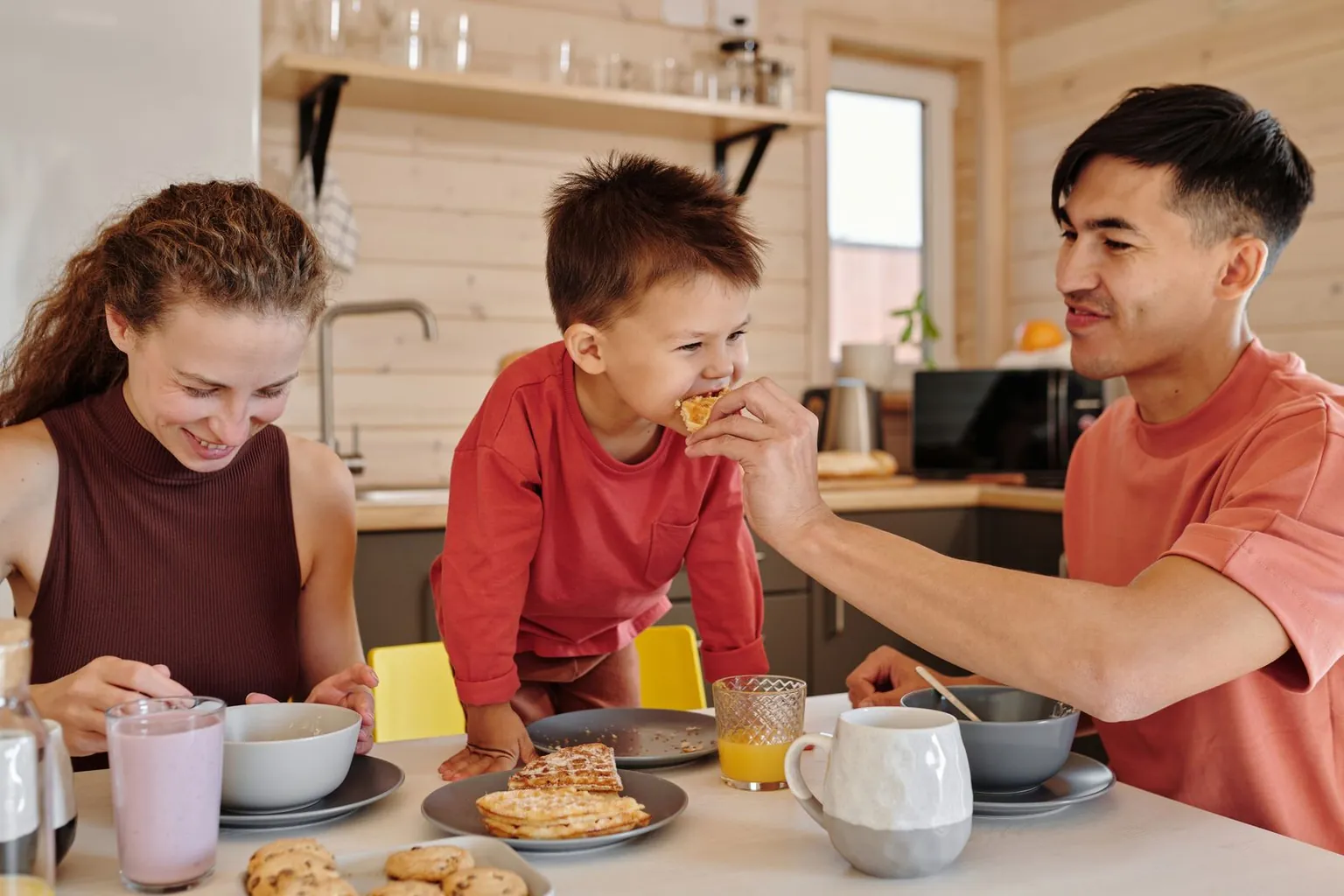Une famille prend son petit-déjeuner autour d’une table.
